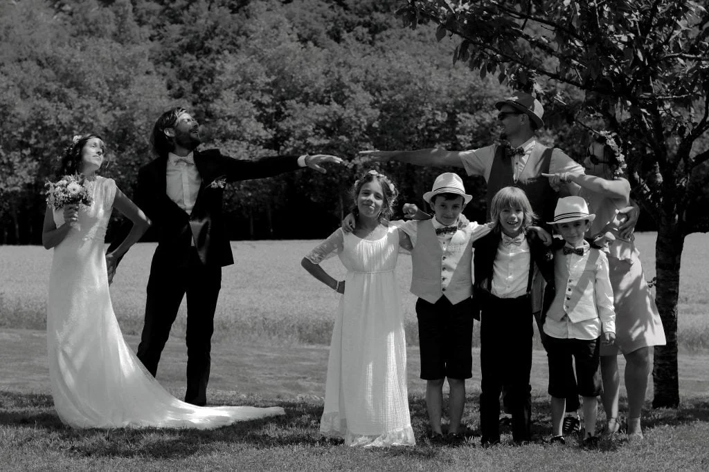 séance photo d'un mariage avec les mariés, les témoins et les enfants dans le domaine