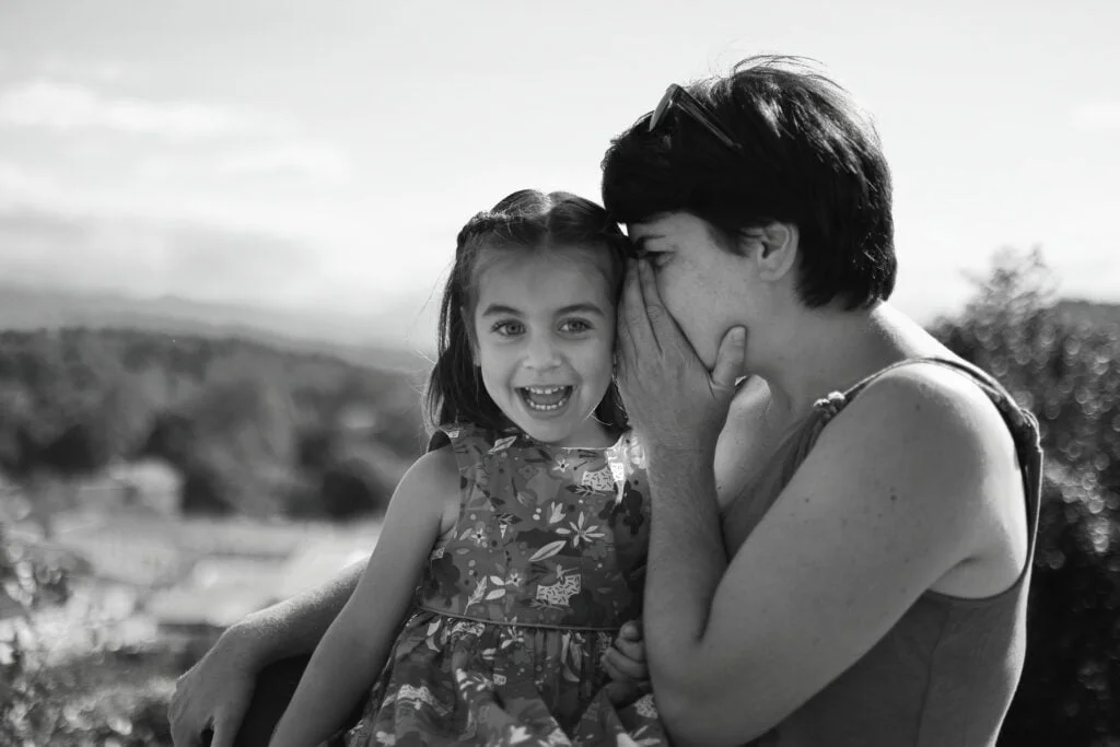 Blog - Les coulisses d'un moment intime dans la campagne Haute Garonnaise en noir et blanc : Une mère et sa fille, capturées dans un moment de complicité et de tendresse, révélant une scène authentique et émotionnelle.